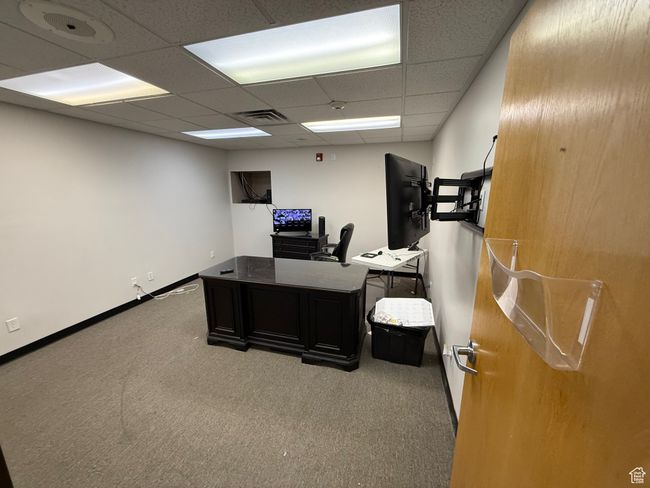 Carpeted home office with baseboards, visible vents, and a drop ceiling | Image 16