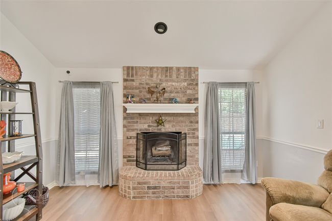 Living room featuring wood finished floors and a brick fireplace | Image 32