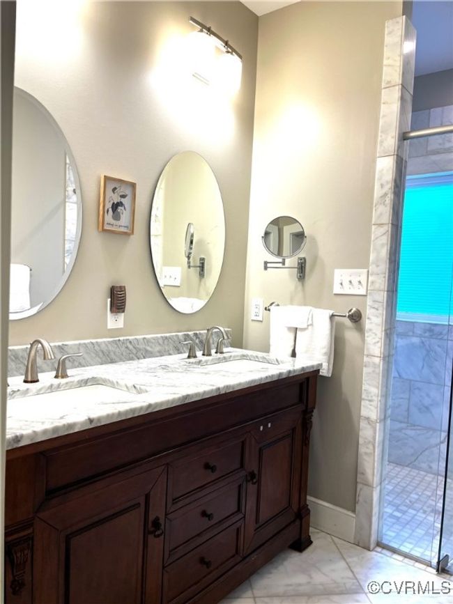 Bathroom featuring marble finish flooring, double vanity, and a stall shower | Image 14