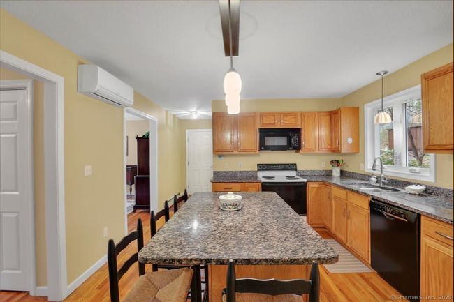 Granite counters, hardwood floors, island with seating for four | Image 6