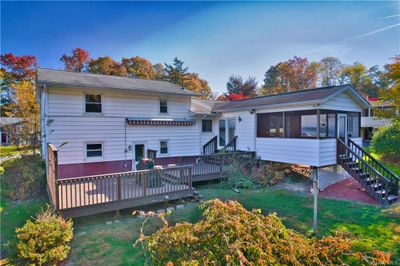 Back of house with a deck, a yard, and a sunroom | Image 2