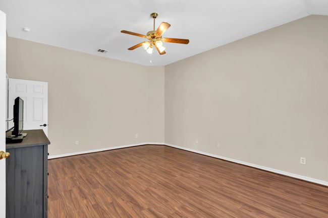 Unfurnished living room featuring dark wood finished floors, visible vents, baseboards, and ceiling fan | Image 22