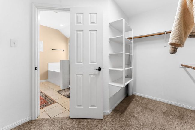 Spacious closet featuring carpet flooring, tile patterned floors, and lofted ceiling | Image 22