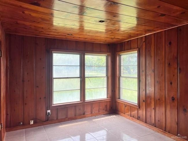 Unfurnished room featuring wooden ceiling and wood walls | Image 7