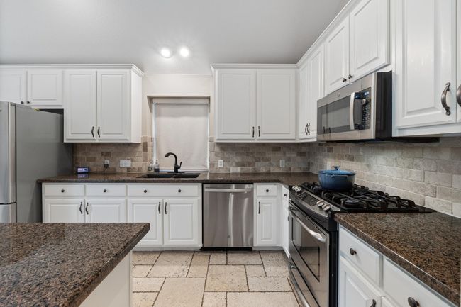 Open kitchen with stainless steel appliances, and view of pool | Image 13