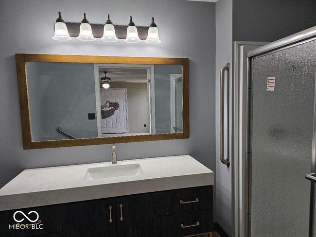 bathroom featuring vanity, a shower stall, and a ceiling fan | Image 19