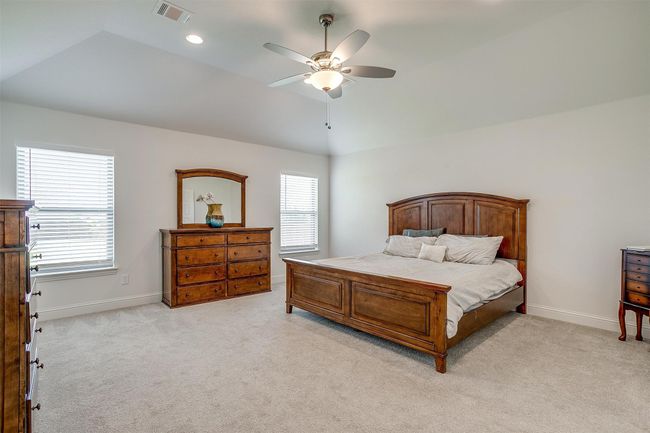 Bedroom featuring lofted ceiling, light colored carpet, baseboards, ceiling fan, and recessed lighting | Image 19