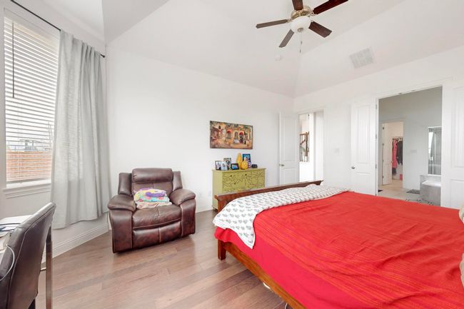 Bedroom featuring visible vents, baseboards, a ceiling fan, light wood-style flooring, and high vaulted ceiling | Image 15