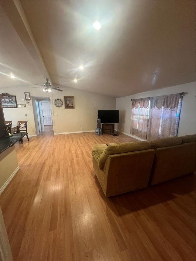 Living area featuring light wood finished floors, ceiling fan, lofted ceiling, and recessed lighting | Image 7