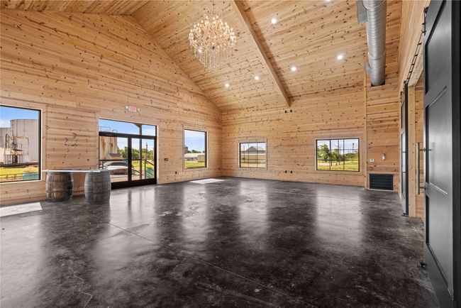 Front foyer featuring high vaulted ceiling, wood walls, plenty of natural light, wooden ceiling, and concrete floors | Image 10