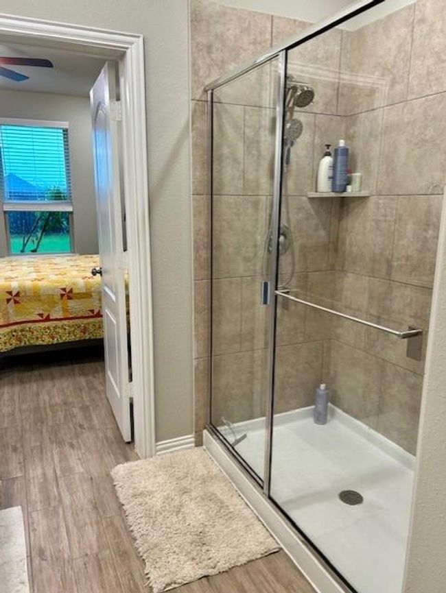 Spacious glass-enclosed shower with modern fixtures, offering a sleek and inviting bathroom experience. | Image 17