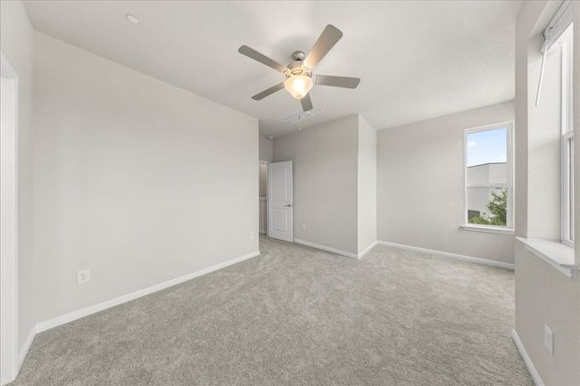 Empty room featuring carpet flooring, a ceiling fan, and baseboards | Image 19