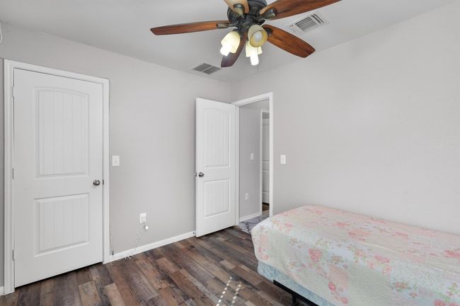 Bedroom with dark wood finished floors, baseboards, and ceiling fan | Image 22