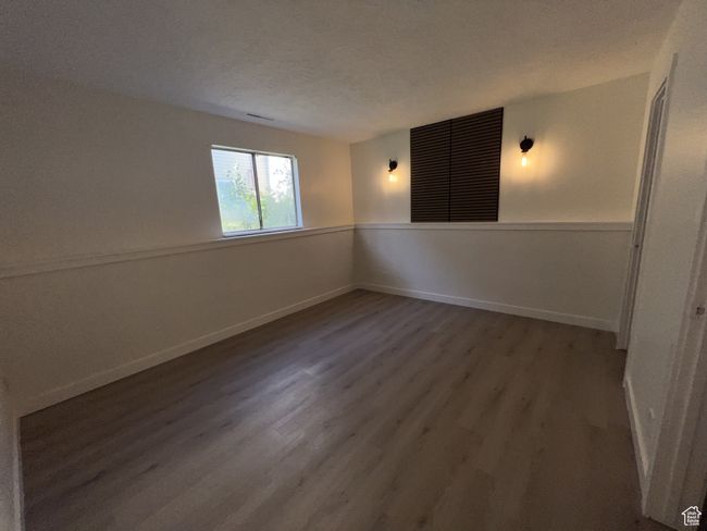 Spare room with wood finished floors, baseboards, and a textured ceiling | Image 9