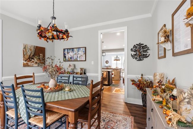 Dining room with crown molding, wood finished floors, and a notable chandelier | Image 9