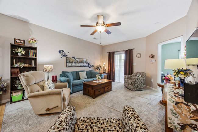 Living room featuring a ceiling fan and baseboards | Image 15