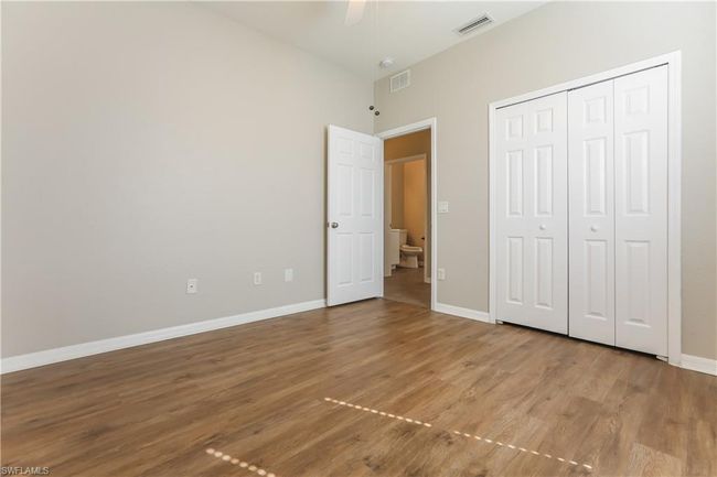 Unfurnished bedroom featuring wood finished floors, a closet, and ceiling fan | Image 12
