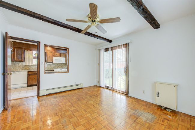 Spare room featuring beam ceiling, baseboard heating, and a ceiling fan | Image 17