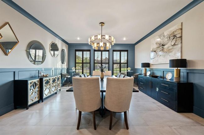 This elegant dining room features a modern chandelier with large windows providing abundant natural light. | Image 14