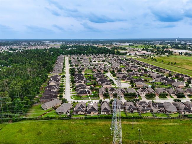 From a vantage point over the greenbelt, this view highlights the home’s serene setting surrounded by nature, showing how seamlessly it blends into the peaceful community landscape. | Image 39