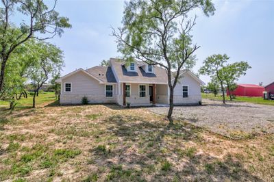 Gorgeous curb appeal with well-crafted architectural design, striking stone masonry, and a welcoming covered front porch with tastefully stained wood pillars. | Image 3