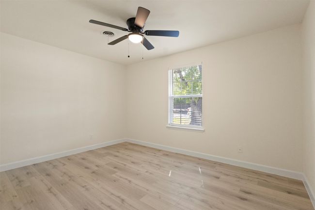 Full bathroom with toilet, wood finished floors, vanity, a shower stall, and baseboards | Image 14