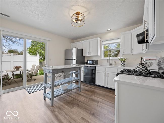 kitchen with all black appliances:gas Range/oven, sliding glass door to the back patio & yard | Image 9