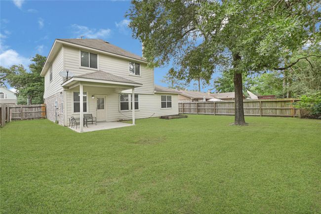 The back exterior of the home showcases the covered patio just off of the breakfast table area. *Grass edited* | Image 29