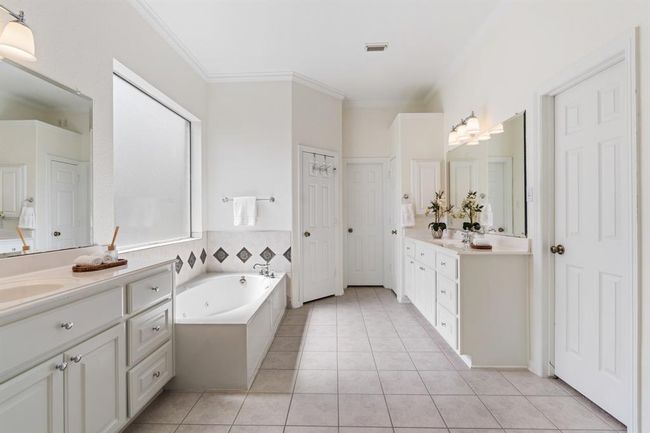 This spa-like bathroom boast double sinks, a separate shower, a soaking tub, water closet, and two walk-in closets. | Image 16