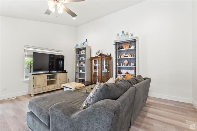 Living area with ceiling fan, light wood-type flooring, and baseboards | Image 5