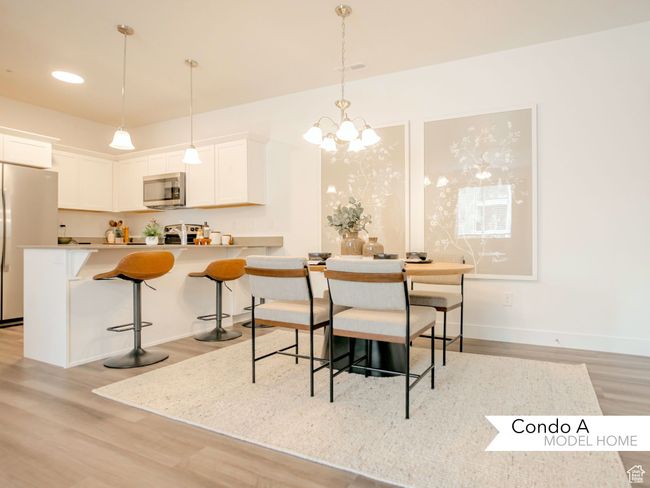 Dining space with a chandelier, light wood finished floors, visible vents, and baseboards | Image 6