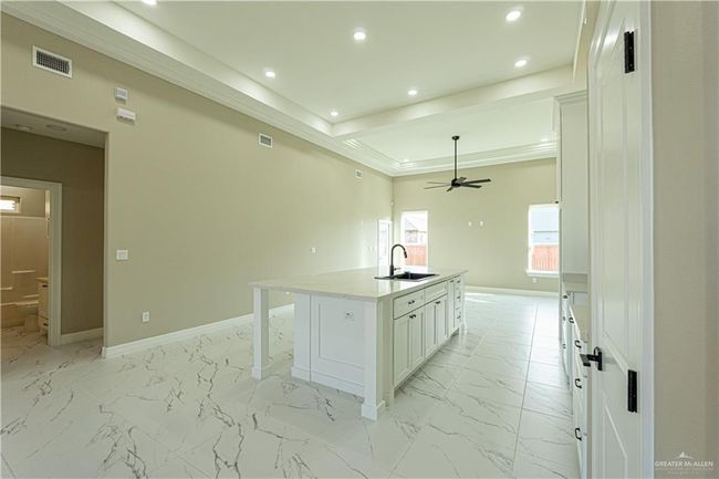 Kitchen featuring marble finish floor, visible vents, white cabinetry, a sink, and baseboards | Image 26