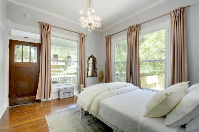 Bedroom featuring large windows, a chandelier, wood finished floors, and crown molding | Image 19