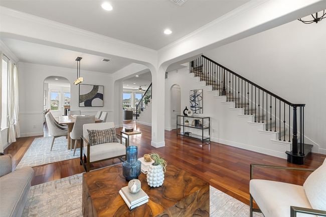 Living room featuring stairs, dark wood-style floors, arched walkways, crown molding, and recessed lighting | Image 10
