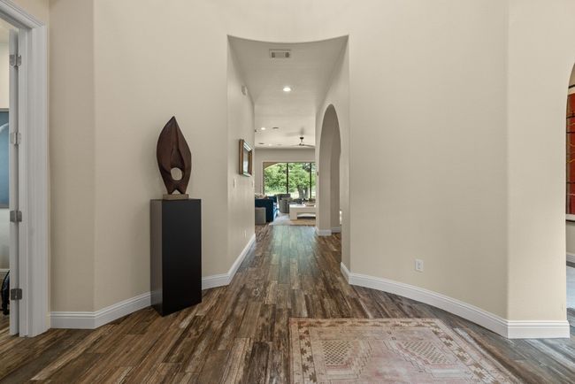 Hallway featuring arched walkways, dark wood finished floors, baseboards, and recessed lighting | Image 6