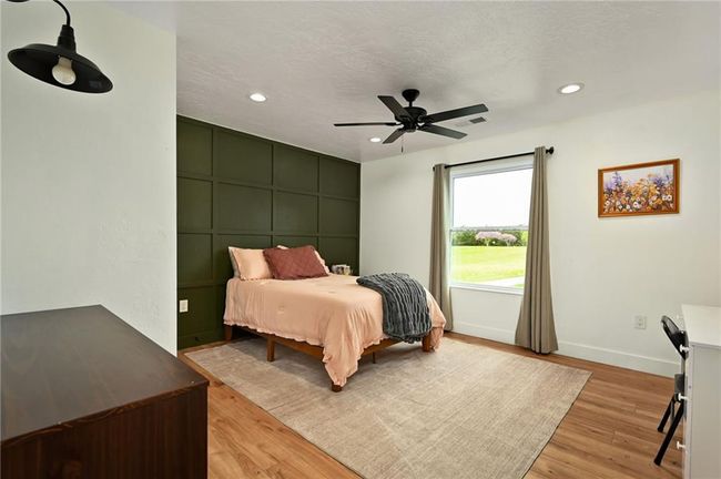 Gorgeous bedroom with accent wall, LVP flooring and ceiling fan. | Image 38