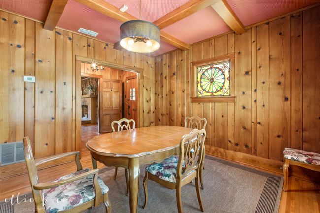Dining space with beamed ceiling, stunning oak floors, knotted pine walls, & stained glass window. | Image 12