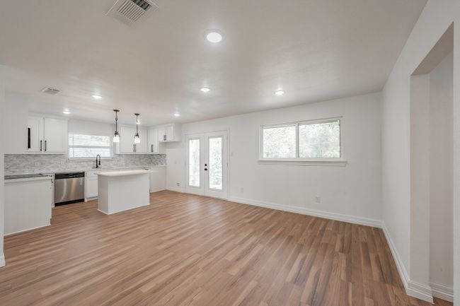 Unfurnished living room featuring light wood-style flooring, baseboards, recessed lighting, and a sink | Image 35