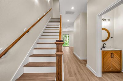 First floor entry with powder room to the right, stained wood accented stairway and living space beyond. | Image 3