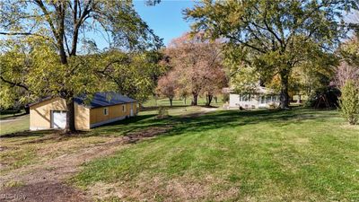 View of yard featuring a garage and an outdoor structure | Image 1