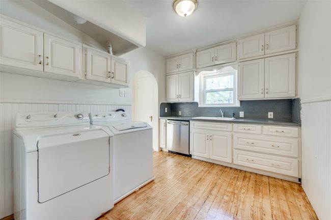 Washroom with independent washer and dryer, light wood-style floors, and arched walkways | Image 31