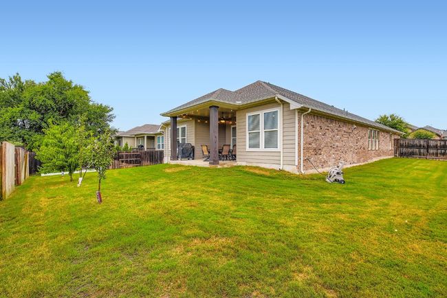Back of property with ceiling fan, a patio area, a fenced backyard, and brick siding | Image 28
