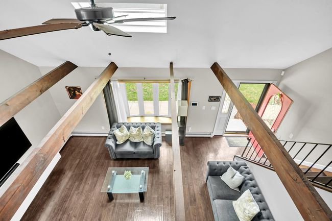 Living area with plenty of natural light, a ceiling fan, wood finished floors, and vaulted ceiling | Image 14