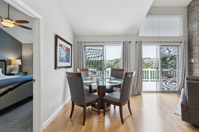 Dining space featuring a ceiling fan, light wood finished floors, lofted ceiling, and baseboards | Image 11