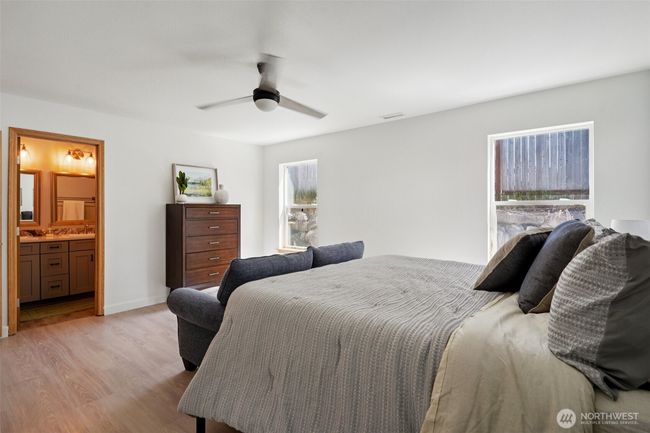 Primary suite has vinyl flooring and huge walk in closet and a bathroom with double sinks and tons of storage | Image 14