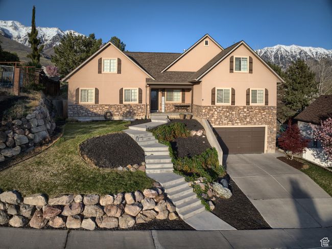 View of front of home with stucco siding, a mountain view, stairs, concrete driveway, and an attached garage | Image 45