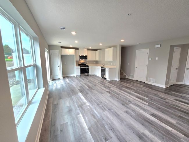 The living room-which serves as a cozy bookend to the area and highlights a space that's flooded in natural light via soaring windows overlooking the back of the home! Photo is of actual home. Colors and options may vary. Ask Sales Agent for details. | Image 18