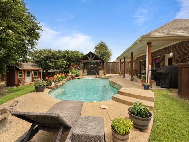 View of swimming pool featuring area for grilling, a patio, an outbuilding, and a fenced backyard | Image 22