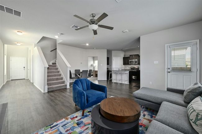 Living area with stairs, dark wood finished floors, and ceiling fan | Image 14