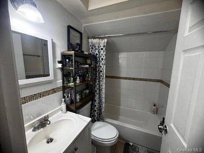 Full bathroom with toilet, shower / tub combo with curtain, and vanity | Image 3